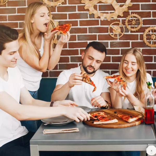 Eine Gruppe Alleinstehender knüpft nette und neue Freundschaften beim Pizza essen