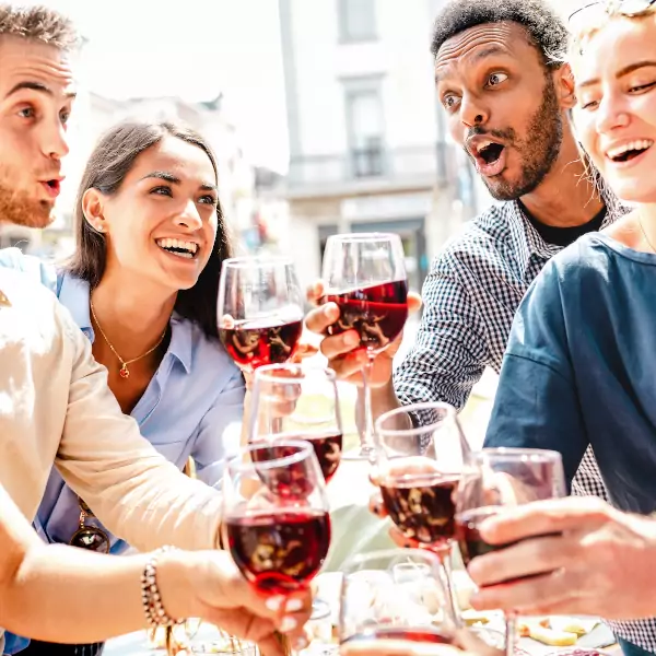 Glückliche Singles die Spass haben beim trink und anstossen mit Rotwein Abendessen Party